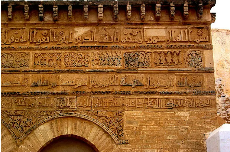 Detailed view of the Kufic inscriptions on the Mosque of Three Doors, featuring Qur'anic verses and records of its construction and restoration.