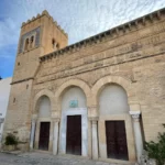 The restored façade of the Mosque of Three Doors in Kairouan after renovations in 1974, preserving its historical and architectural integrity.